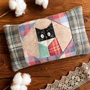 Finished flannel cat heating pad made with soft plaid fabric and patchwork cat design on wooden table