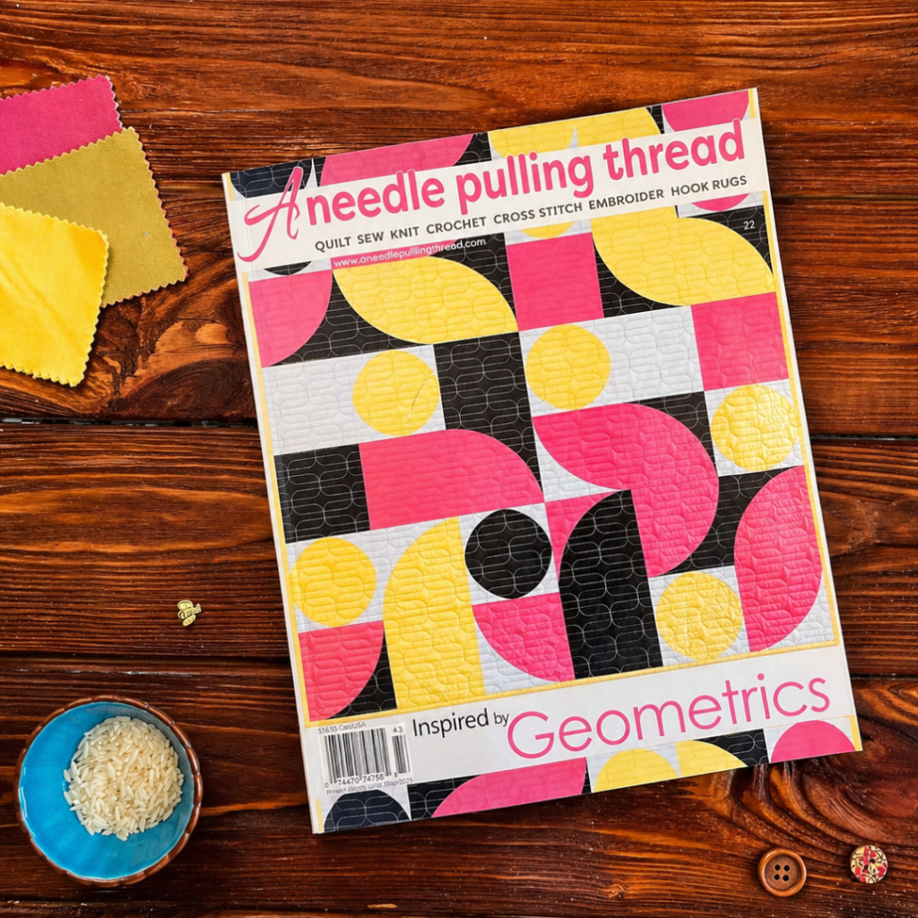 Cover of A Needle Pulling Thread magazine Inspired by Geometrics issue on wooden table